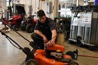 student working on lawn mower